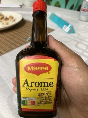 Bouteille d'Arôme Maggi tenue en main